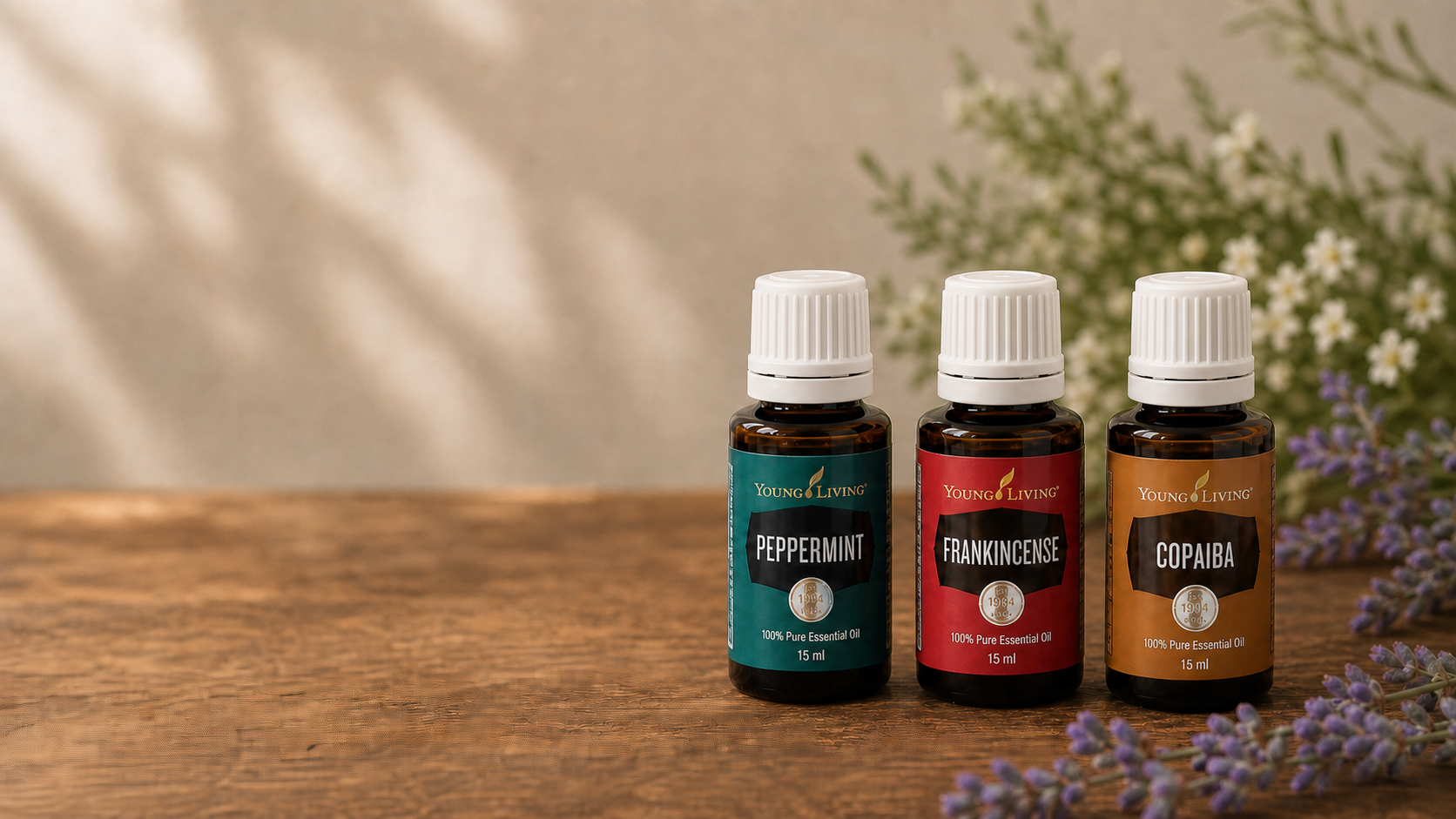 Young Living Öle mit weißen Deckeln, Pfefferminze, Weihrauch und Copaiba in einer natürlichen Umgebung